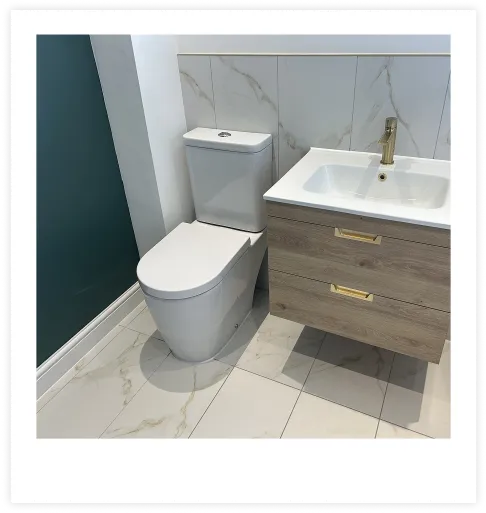 A photograph of a toilet and sink fitted by Design Heating