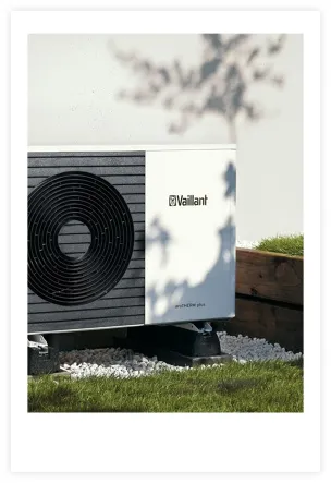 Image of a Vaillant heat pump in front of a house with grass in the foreground