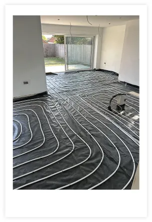 Underfloor heating being installed with lining covered by loops of pipework